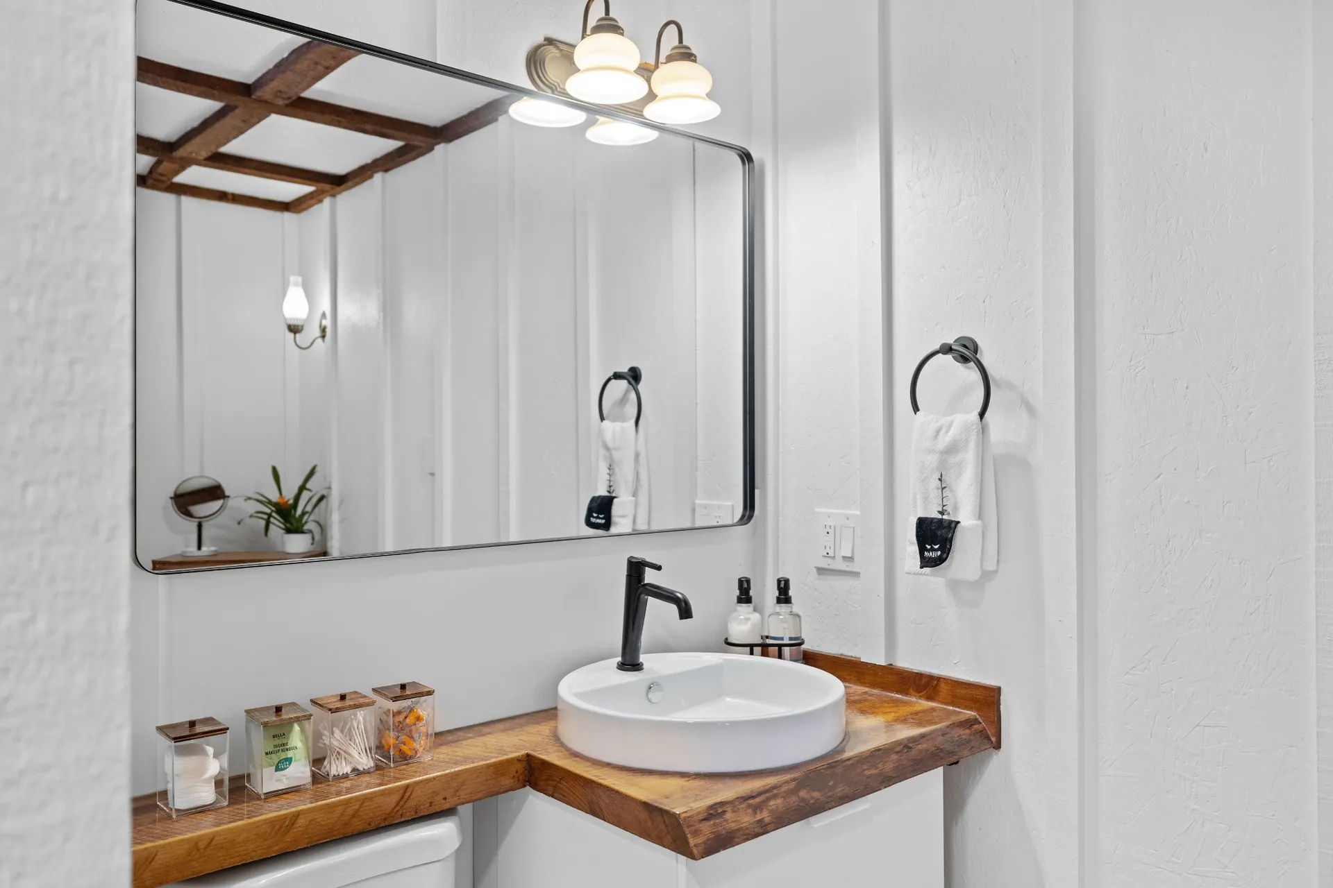 Custom rectangular bathroom mirror above a wood vanity with vessel sink