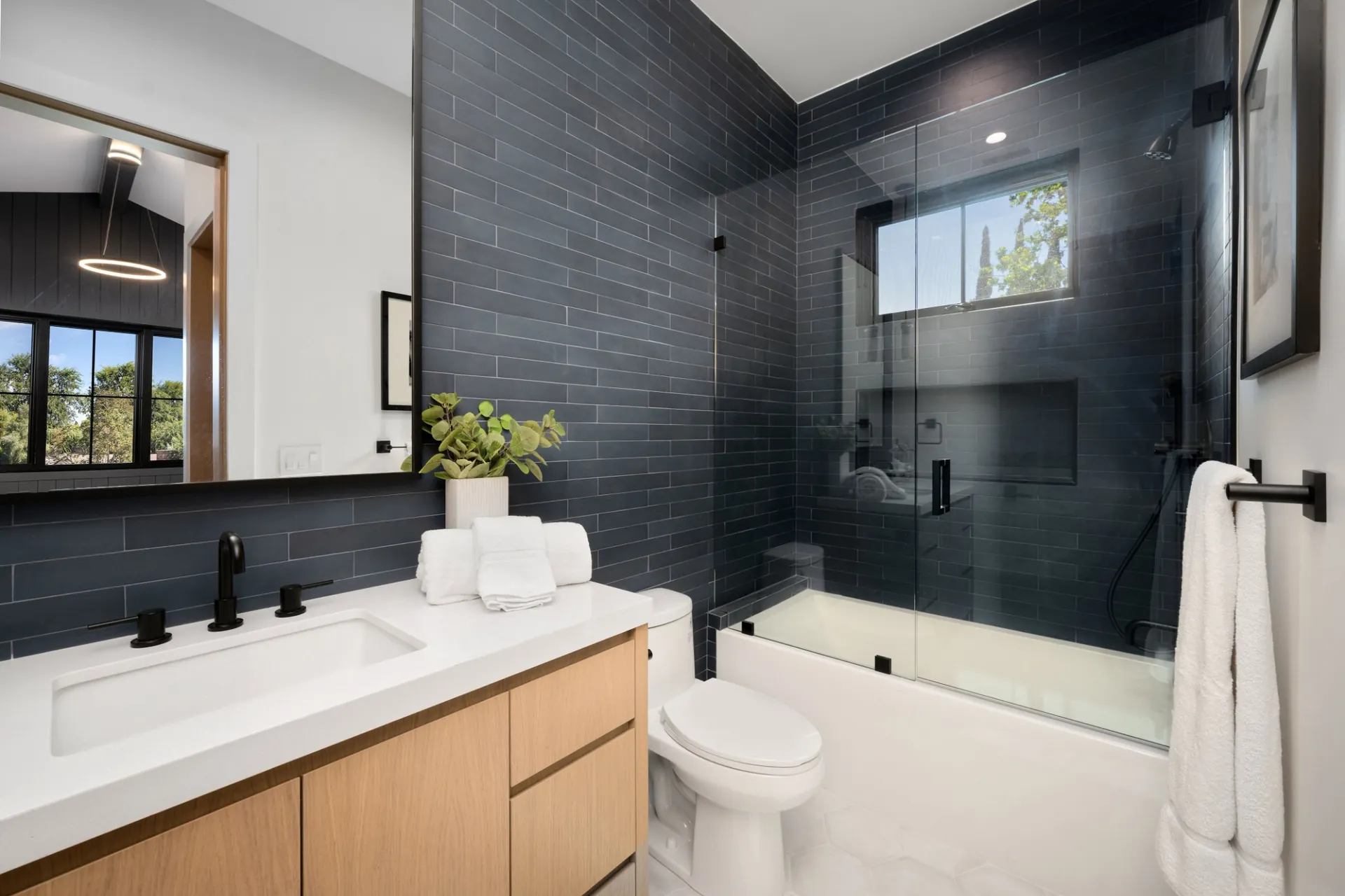 Modern bathroom with frameless shower glass and blue tile